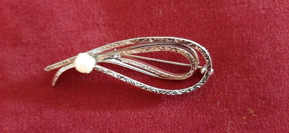 Elegant silver tone brooch with scroll design & pearl.