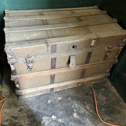 Antique canvas-covered steamer trunk with wooden slats and metal hardware.