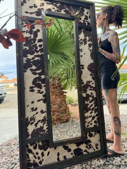 Handmade cowprint and feathered mirror