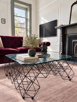 Glass coffee table with sculptural metal base
