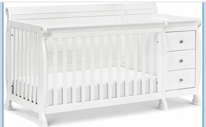 Crib with attached changing table, drawers, shelves and converts to a toddler bed