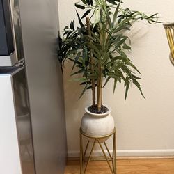 Two artificial plants with gold stands