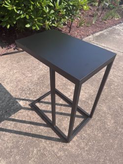 Black metal C-shaped side table