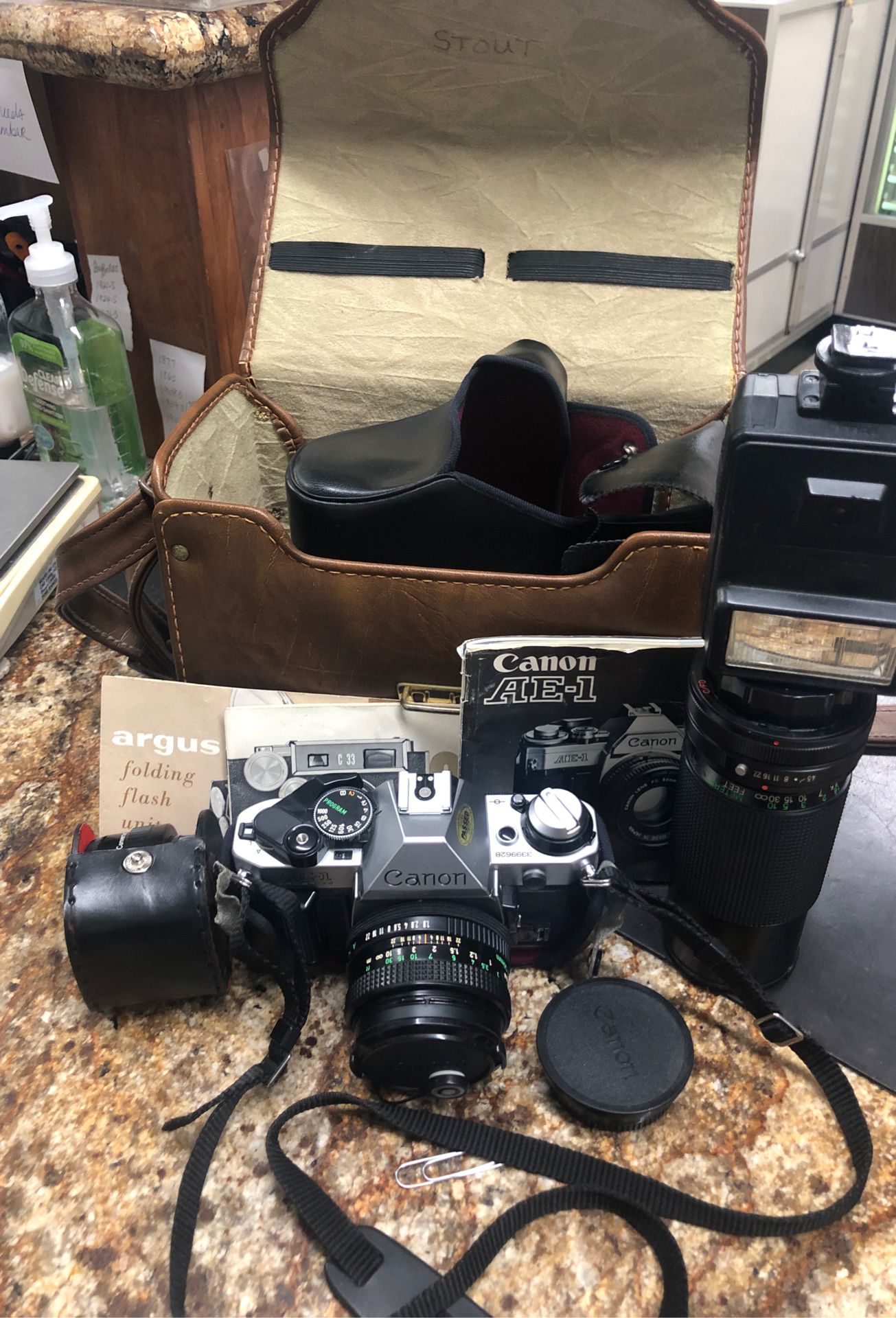 Canon AE-1 camera with three lenses, flash, original case and paperwork