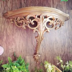 Hanging shelf in golden color.