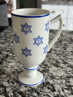 White ceramic mug with blue Star of David and menorah design
