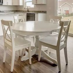 White extendable kitchen table and four white chairs