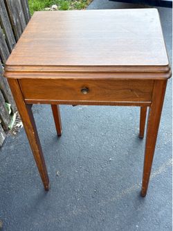 Vintage Kenmore Sewing machine in a walnut cabinet with attachments