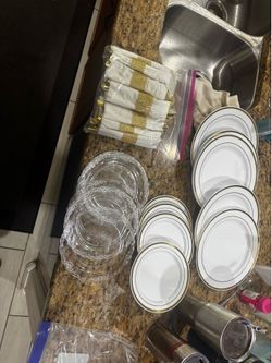 Elegant plastic dinnerware set includes rim accents and clear, decorative plates and stylish utensils wrapped