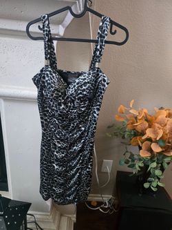 Elegant black and white animal print dress with ruched detailing for a flattering fit. Silver accents on straps, great dress with a zipper on the side