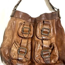 The handbag in the image is the Banana Republic Ashbury large leather hobo shoulder bag in brown. This model is notable for its soft, distressed leath