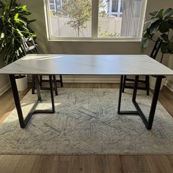 Modern table featuring a smooth polished concrete top paired with sturdy black matte metal legs. The minimalist design is durable, stylish, and perfec