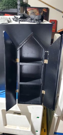 coffin-shaped cabinet or curio shelf