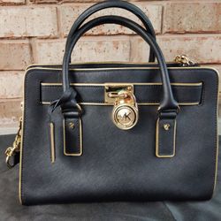 The Michael Kors Hamilton Small Satchel is a stylish and practical handbag designed for women. Made from black leather with gold hardware, this satche