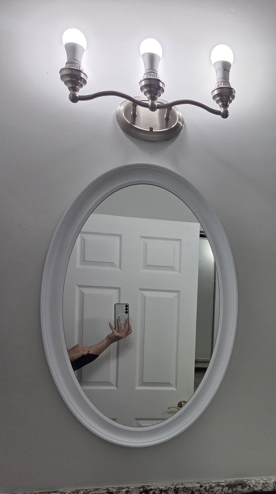 Three white, oval bathroom mirrors