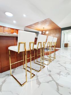 Set of 4 like new white leather gold bar stools.