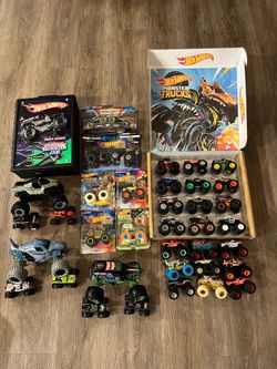 collection of Hot Wheels Monster Trucks toy vehicles, primarily featuring the Hot Wheels Monster Trucks Ultimate Chaos 12-Pack.  Brand: Hot Wheels Ite