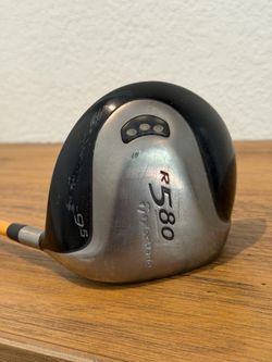 TaylorMade R580 driver head. 9.5° loft marking on the sole. Streamlined shape for low-spin performance. Classic black and silver colorway. Ready for c