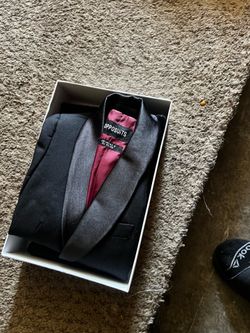 Opposuits black tuxedo jacket featuring a satin shawl lapel and a maroon lining.