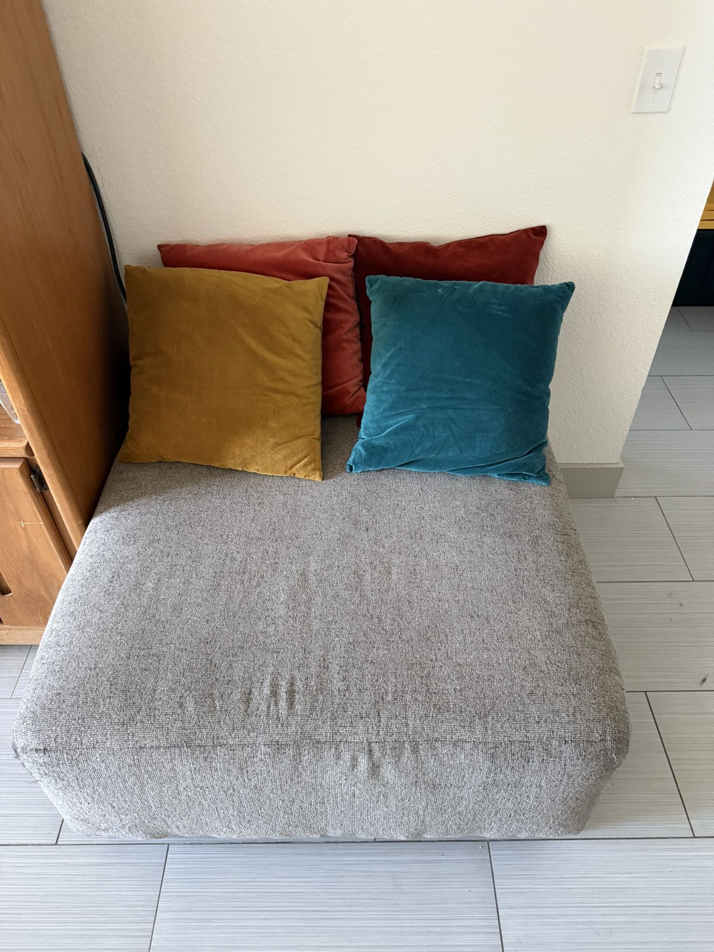 Grey Ottoman + Multi Colored Throw Pillows