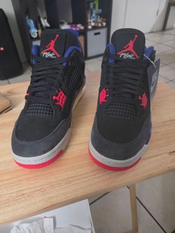Air Jordan 4 Retro 'Rare Air' sneakers featuring a black nubuck upper, red eyelets, and royal blue accents
