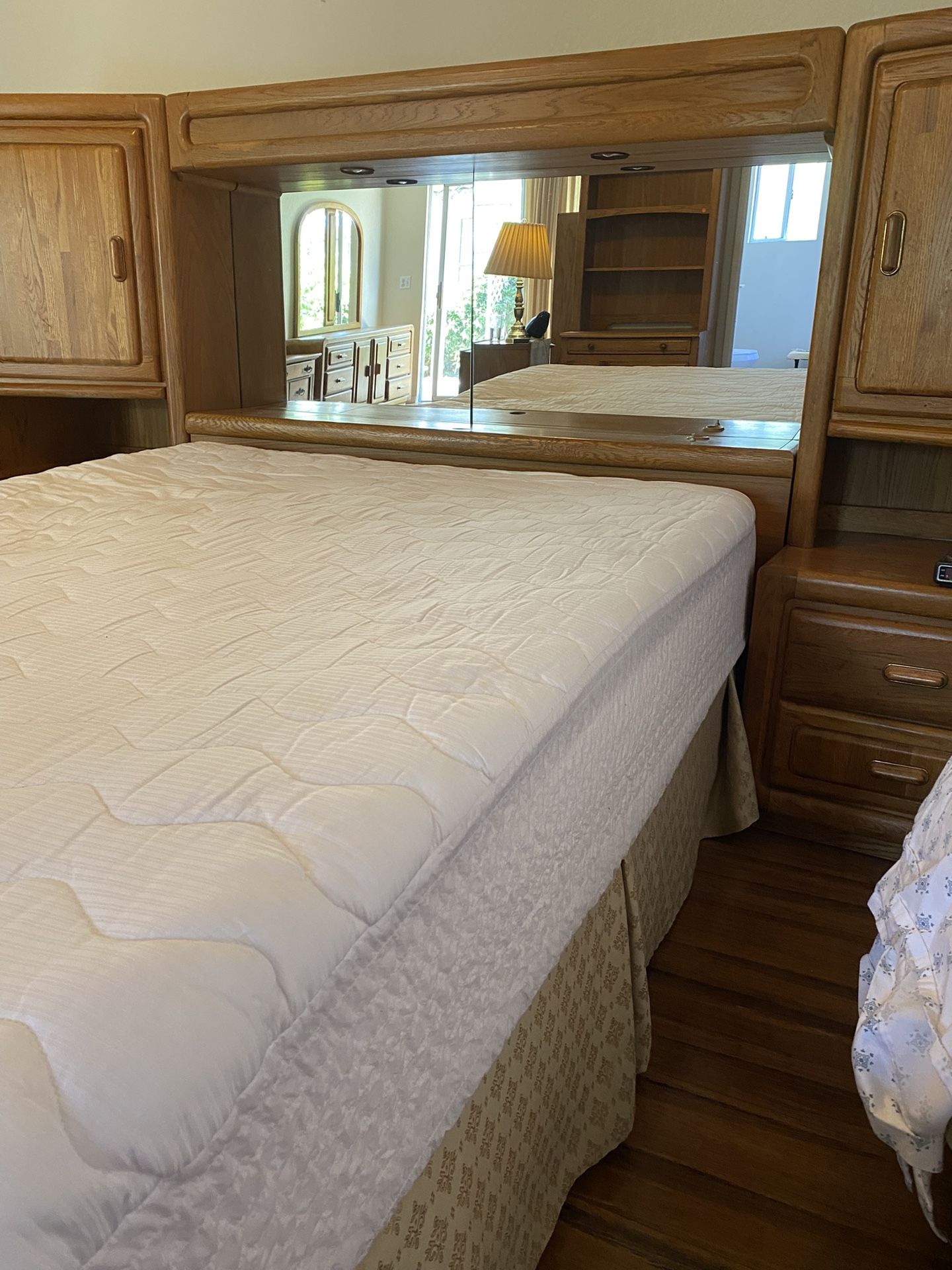Oak queen sized bed with Storage cabinets and mirror.