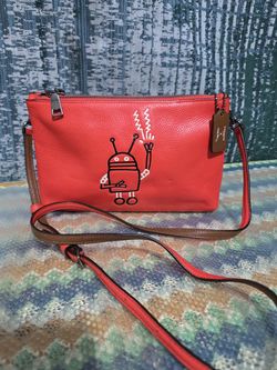 Coach x Keith Haring Lyla crossbody bag in orange pebbled leather featuring a robot design.  # Y
