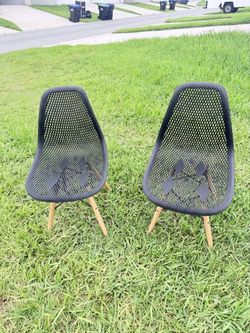 Selling 2 black accent chairs with tapered wooden legs.