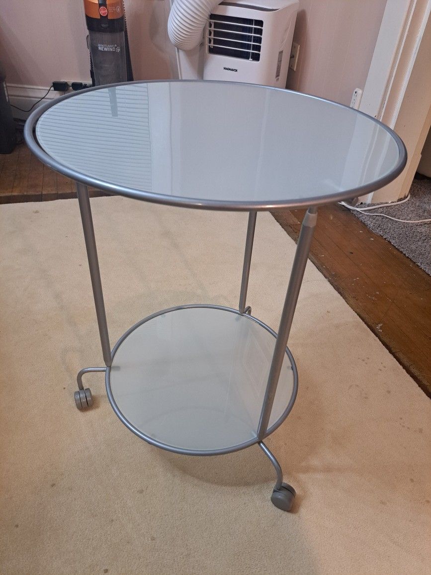 This IKEA Heimdal glass and metal rolling side table