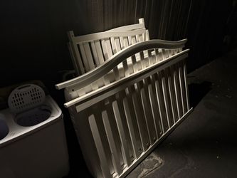 White-painted wooden crib frame, mattress, box springs, and screws for assembly.