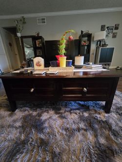 This is a dark wood coffee table with two drawers