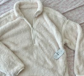 Ultra-soft cream sherpa pullover with a half-zip neckline. Lightweight yet warm fleece for everyday layering. Relaxed fit with trimmed seams for a cle
