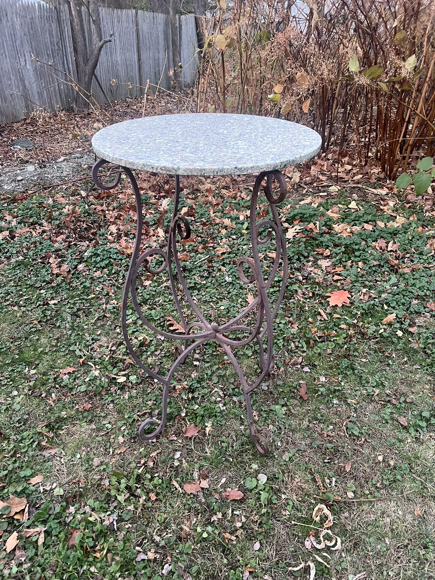 vintage wrought iron patio bistro table with a granite top.