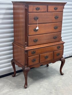 vintage Queen Anne style highboy dresser featuring distinctive cabriole legs and dark bras