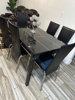Glass dining table with 6 leather chairs.