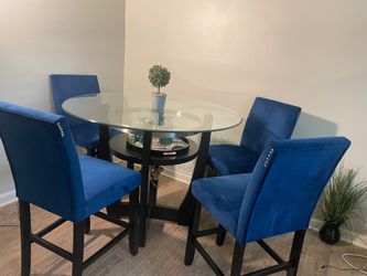 Glass dinning table with 4 blue chairs.
