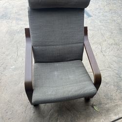 IKEA POÄNG armchair with a dark brown bentwood frame and a gray woven cushion