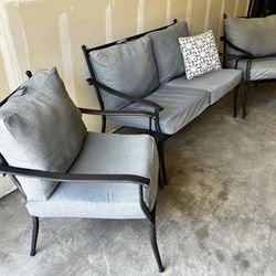 Pretty outdoor patio three-piece seating set with soft charcoal gray cushions. Sturdy and lightweight black aluminum frames are in very good condition