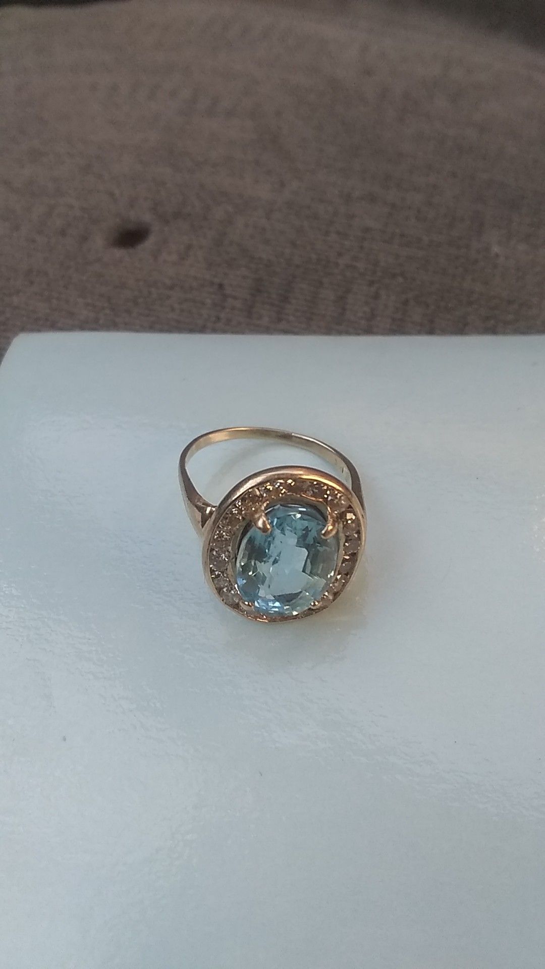 4 pennyweight 14 karat gold ring with 1 -9. 1 x11. 6 x 6. 7 mm oval step cut transparent medium blue topaz and 18-.05 carat diamonds
