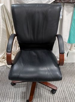 Comfortable black leather executive office chair/rich mahogany wood frame.