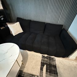Black Couch And Arm Chair With A Coffee Table 