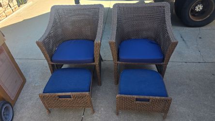 Set of 2 wicker patio chairs with ottomans.