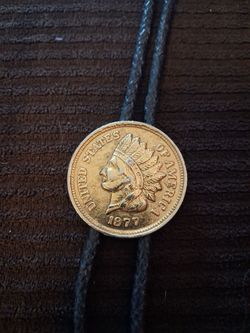 vintage style bolo tie featuring a round coin pendant on a braided cord