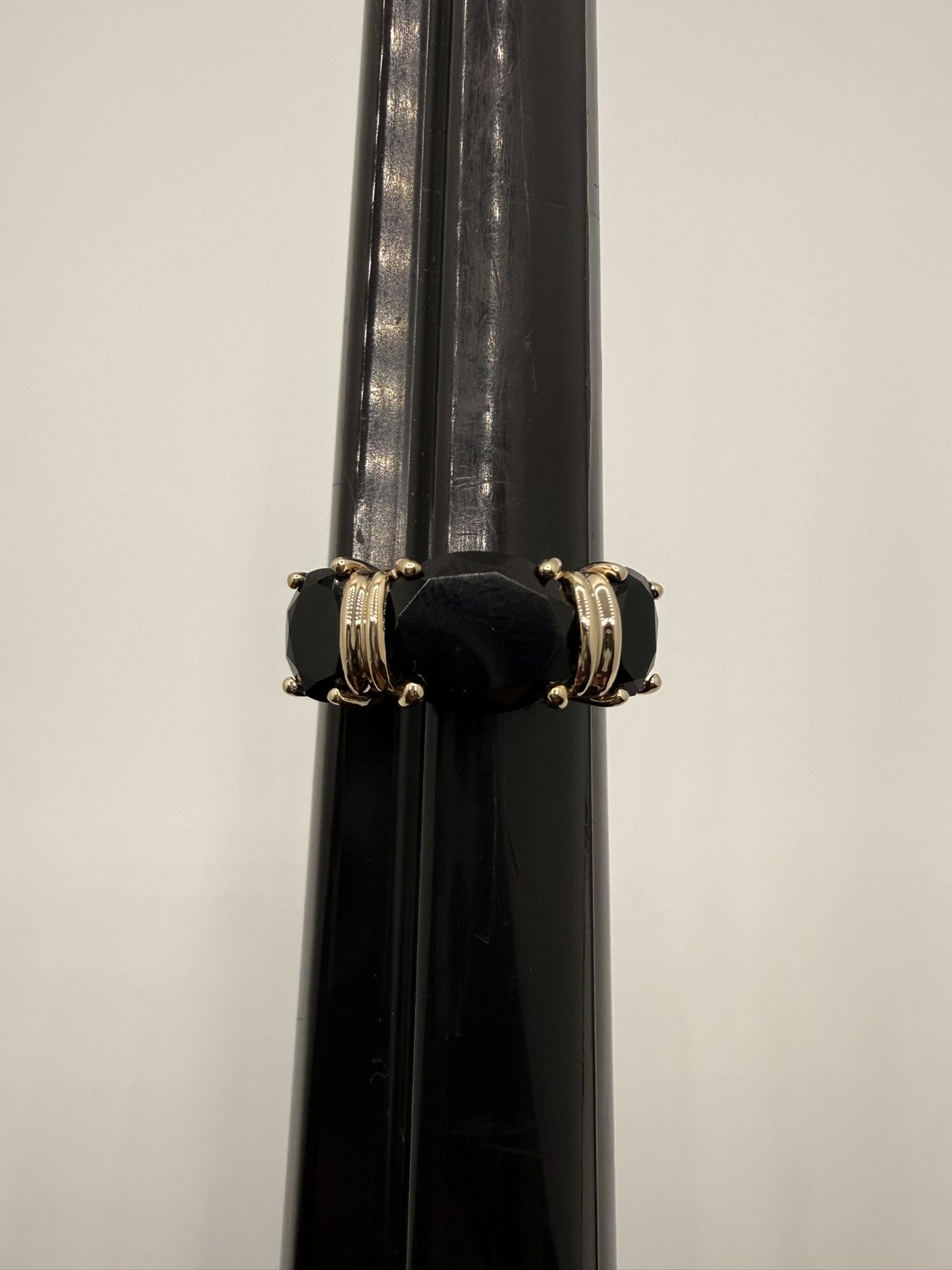 14k three-stone ring with faceted oval black onyx stones set in yellow gold