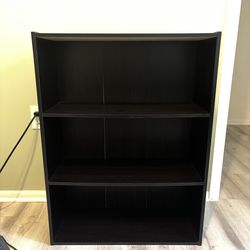 3 tier black wood shelf. About 3 1/2 ft tall