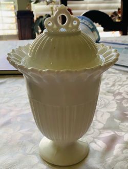 vintage Fostoria Randolph milk glass footed urn with a lid, identified by its distinct ribbed pattern and ornate finial.