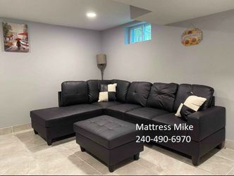 New in box black faux leather sectional with ottoman and pillows