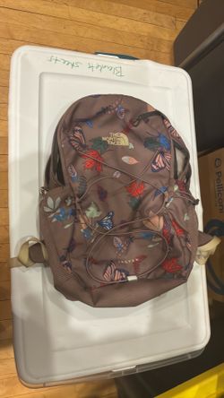 Model:  NORTH FACE Jester Backpack Color      taupe/brown base with a multicolor butterfly + leaf print