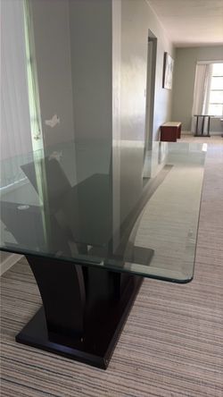 Glass top dining table with dark wood on the bottom