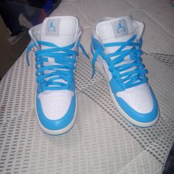 Air Jordan 1 Mid Light Blue, Grey Nike Logo, And White.